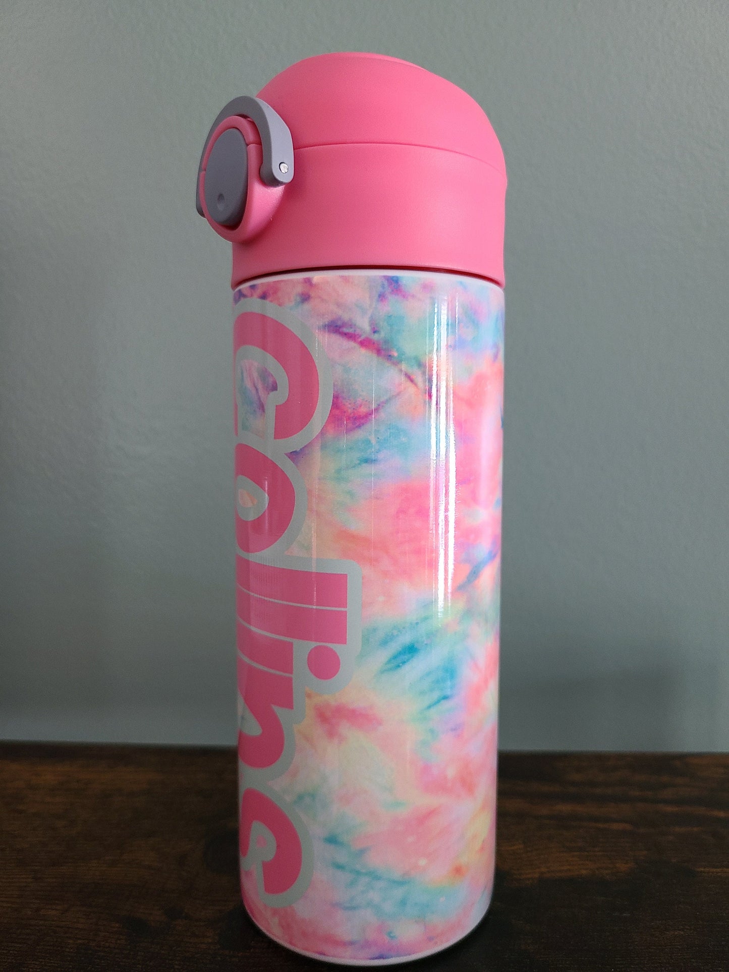 12 oz water bottle with flip top and built in straw. Pink tie dye themed water bottle for kids. Back to school water bottle for kids. Tie dye in pastel colors with a name in pink and pink lid.