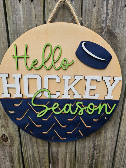 Round wooden sign with 'Hello Hockey Season' text and hockey puck design on a wooden background