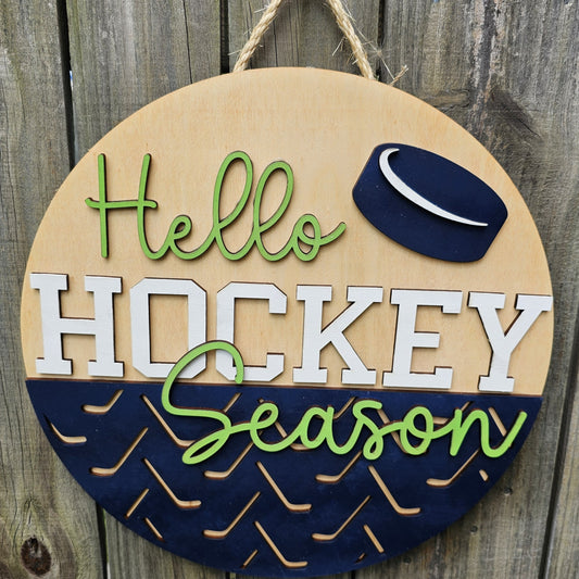 Round wooden sign with 'Hello Hockey Season' text and hockey puck design on a wooden background