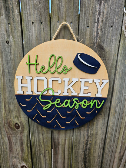 Round wooden sign with 'Hello Hockey Season' text and hockey puck design on a wooden background