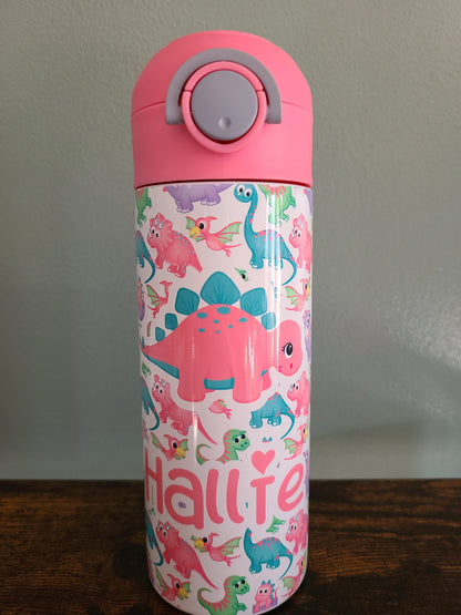 12 oz water bottle with pink lid that has a built in straw, locking push button and handle. This design features pastel rainbow dinosaurs. Personalized in coordinating colors. Back to School.