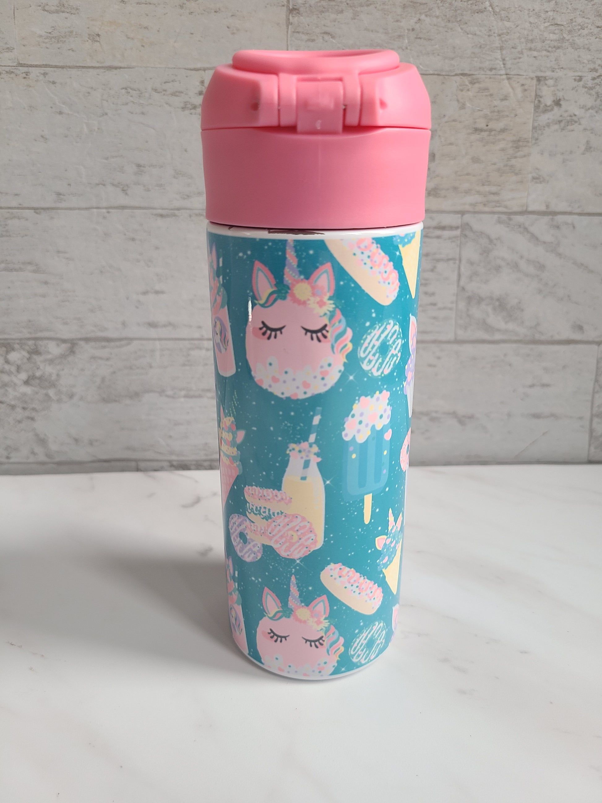 12 oz water bottle with pink lid that has a built-in straw, locking push button and handle. This design features pastel unicorn cupcakes and ice cream cones. Personalized in coordinating colors. Back to School.