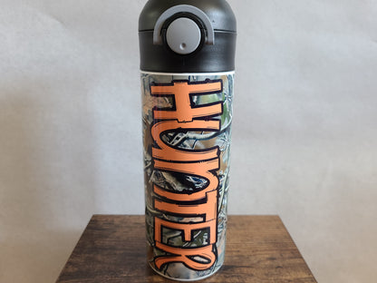 12 oz water bottle with a black lid that has a built-in straw, locking push button and handle. This design features real tree camo with orange personalization. Back to School.