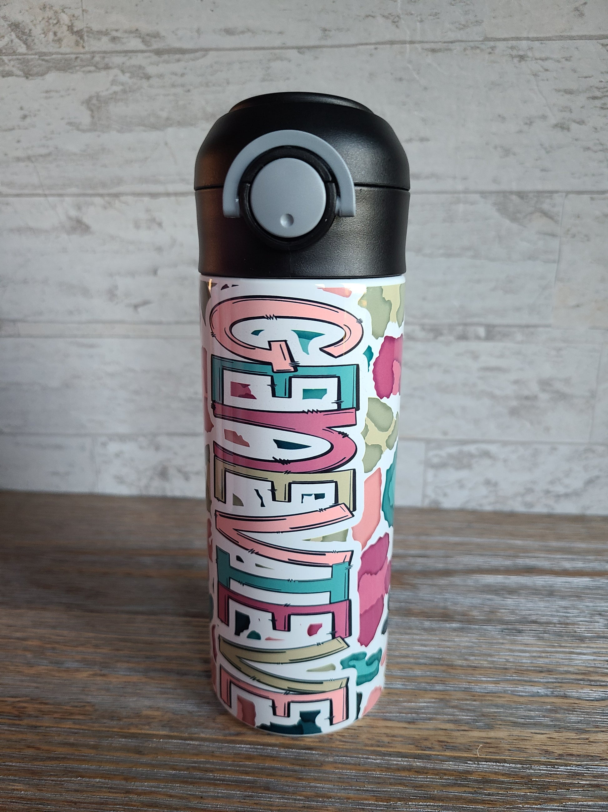  12 oz water bottle with a black lid that has a built-in straw, locking push button and handle. This design features a white background multi-colored leopard print. Personalized in coordinating colors. Back to School.