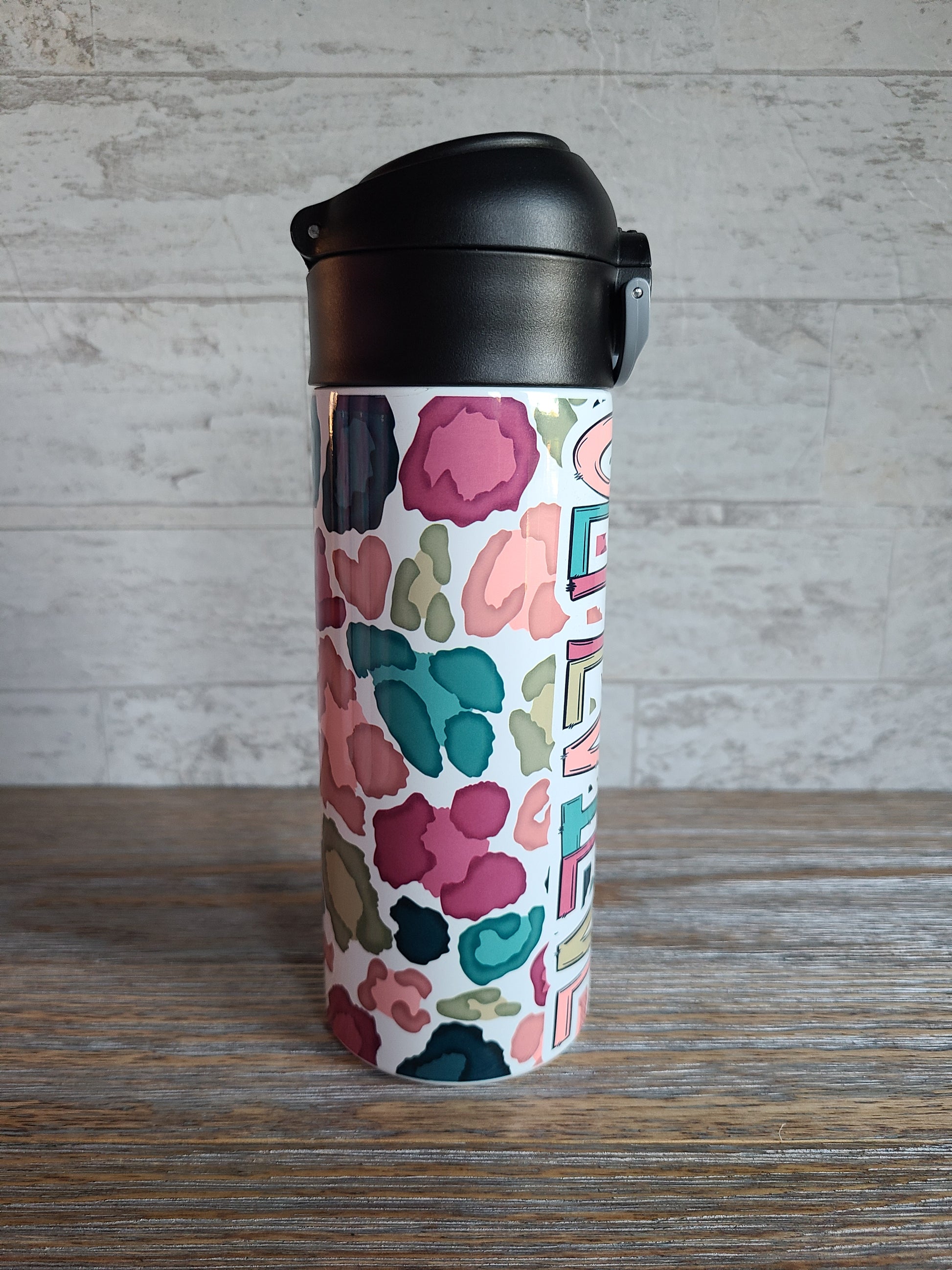 12 oz water bottle with a black lid that has a built-in straw, locking push button and handle. This design features a white background multi-colored leopard print. Personalized in coordinating colors. 