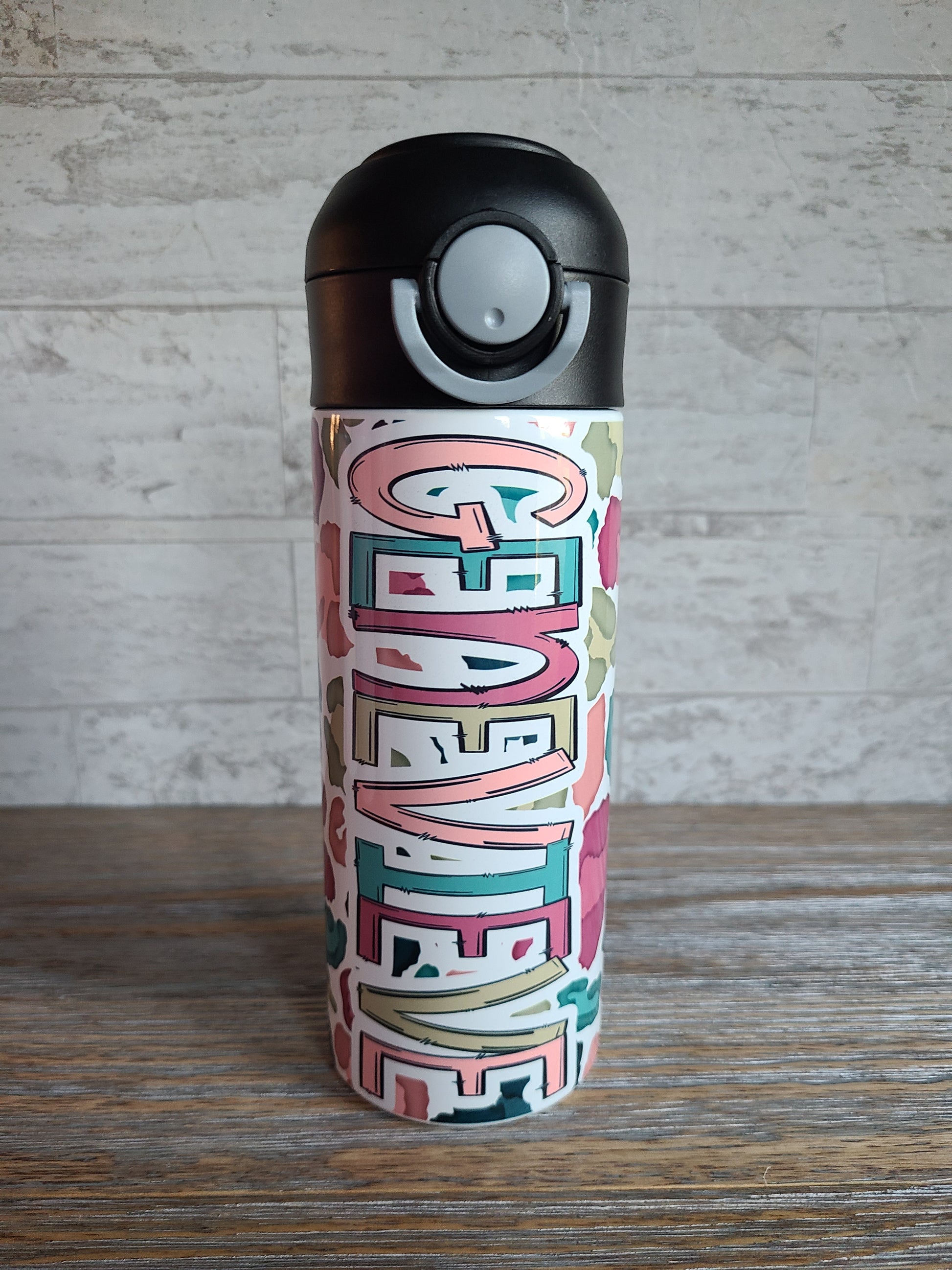 12 oz water bottle with a black lid that has a built-in straw, locking push button and handle. This design features a white background multi-colored leopard print. Personalized in coordinating colors.
