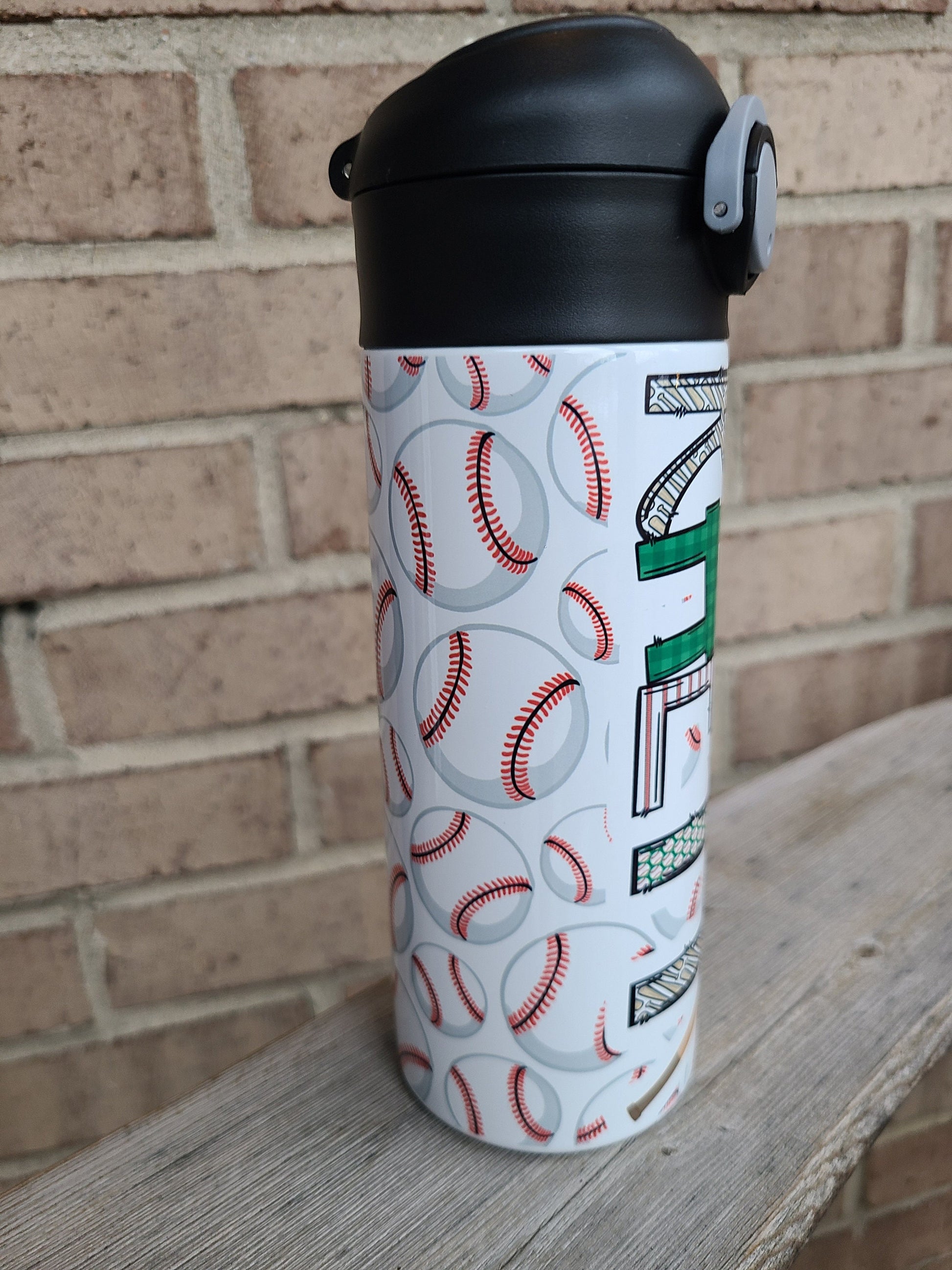 12 oz water bottle with a black lid that has a built-in straw, locking push button and handle. This design features multiple baseballs with a glove and bat print. Personalized in coordinating colors. Back to School.