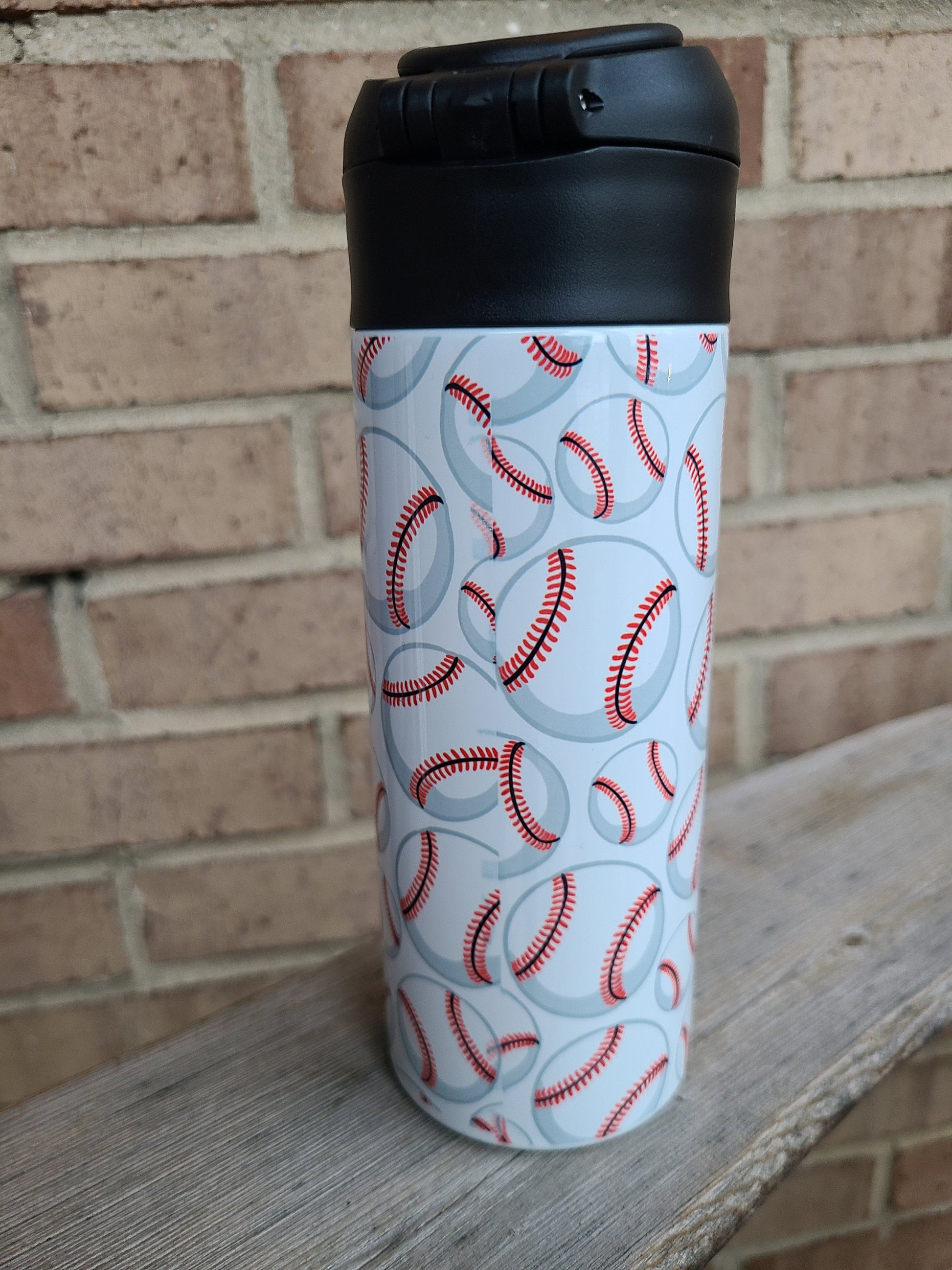 12 oz water bottle with a black lid that has a built-in straw, locking push button and handle. This design features multiple baseballs with a glove and bat print. Personalized in coordinating colors. Back to School.